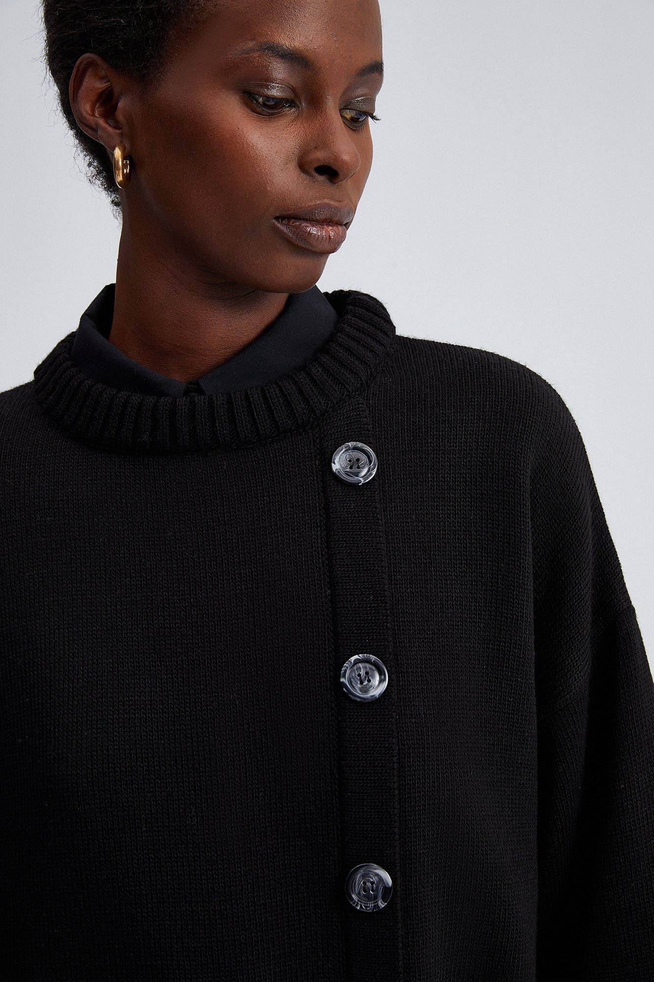 Maglione nero oversize con bottoni asimmetrici