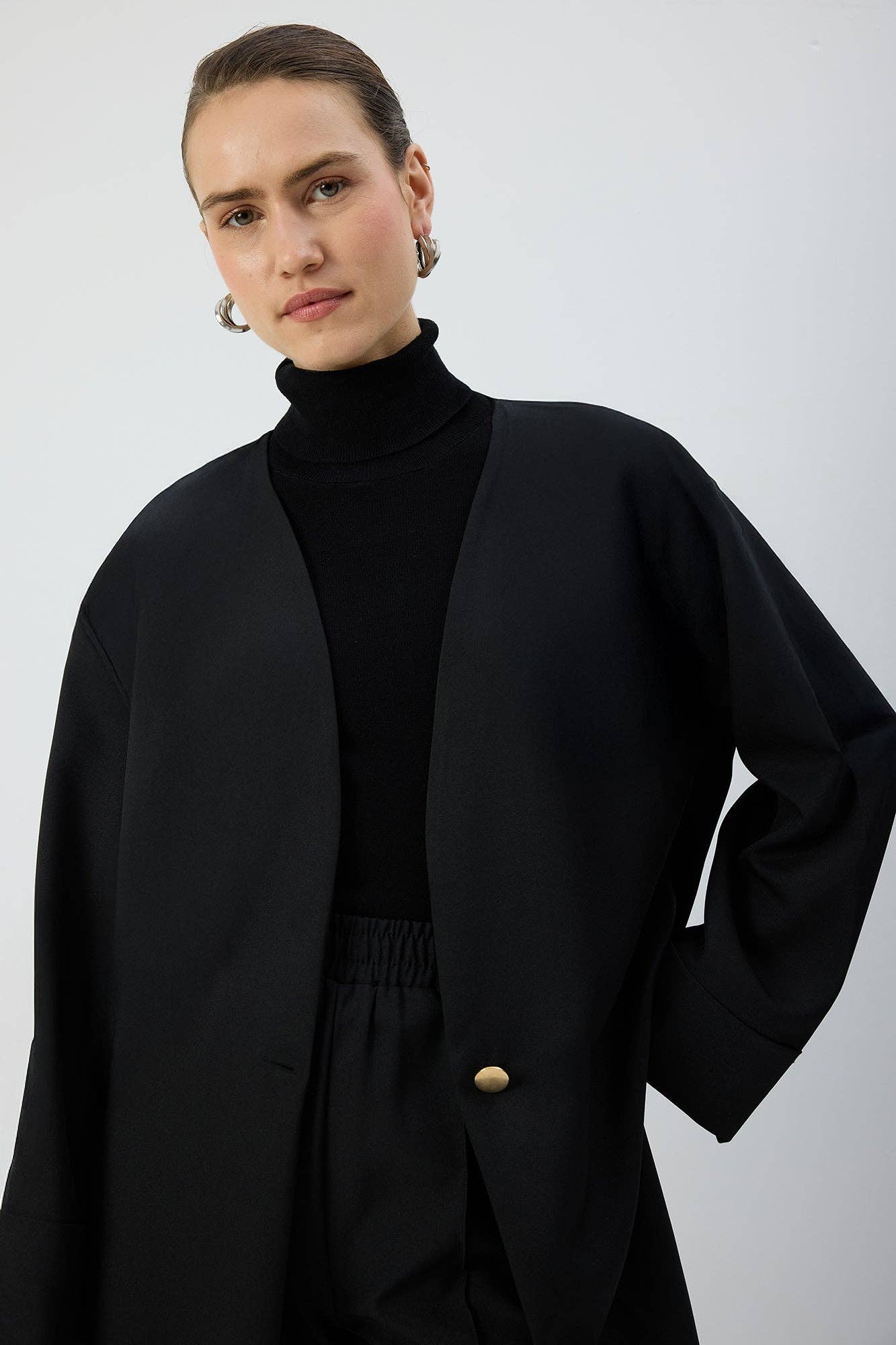 Giacca nera oversize con scollo a V e bottone
