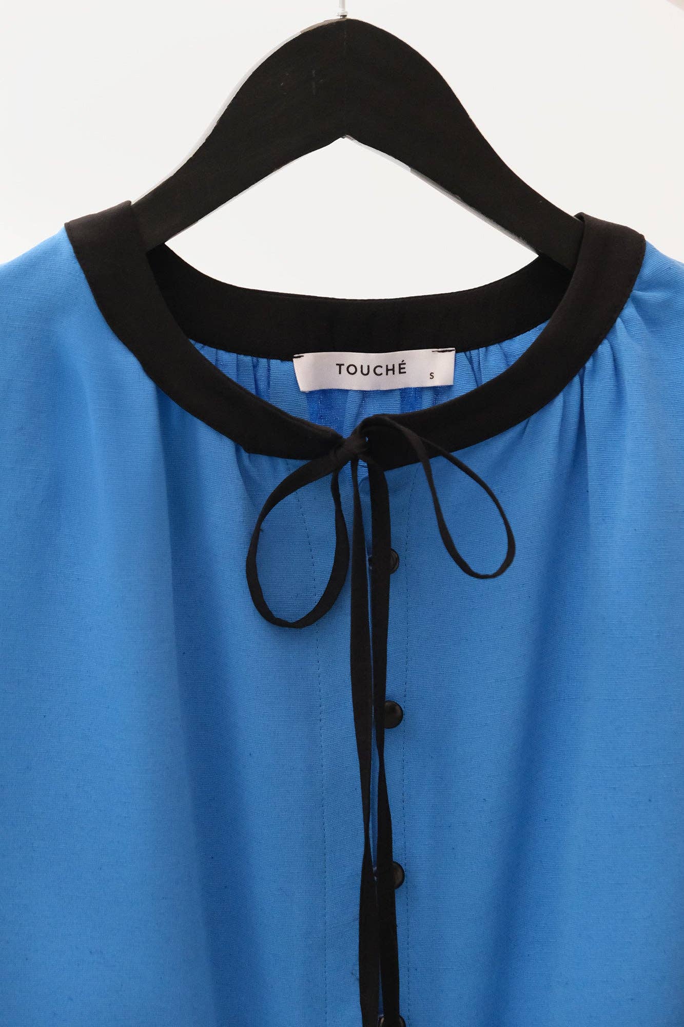 Blusa in misto lino blu con bordo a contrasto e fiocco al collo