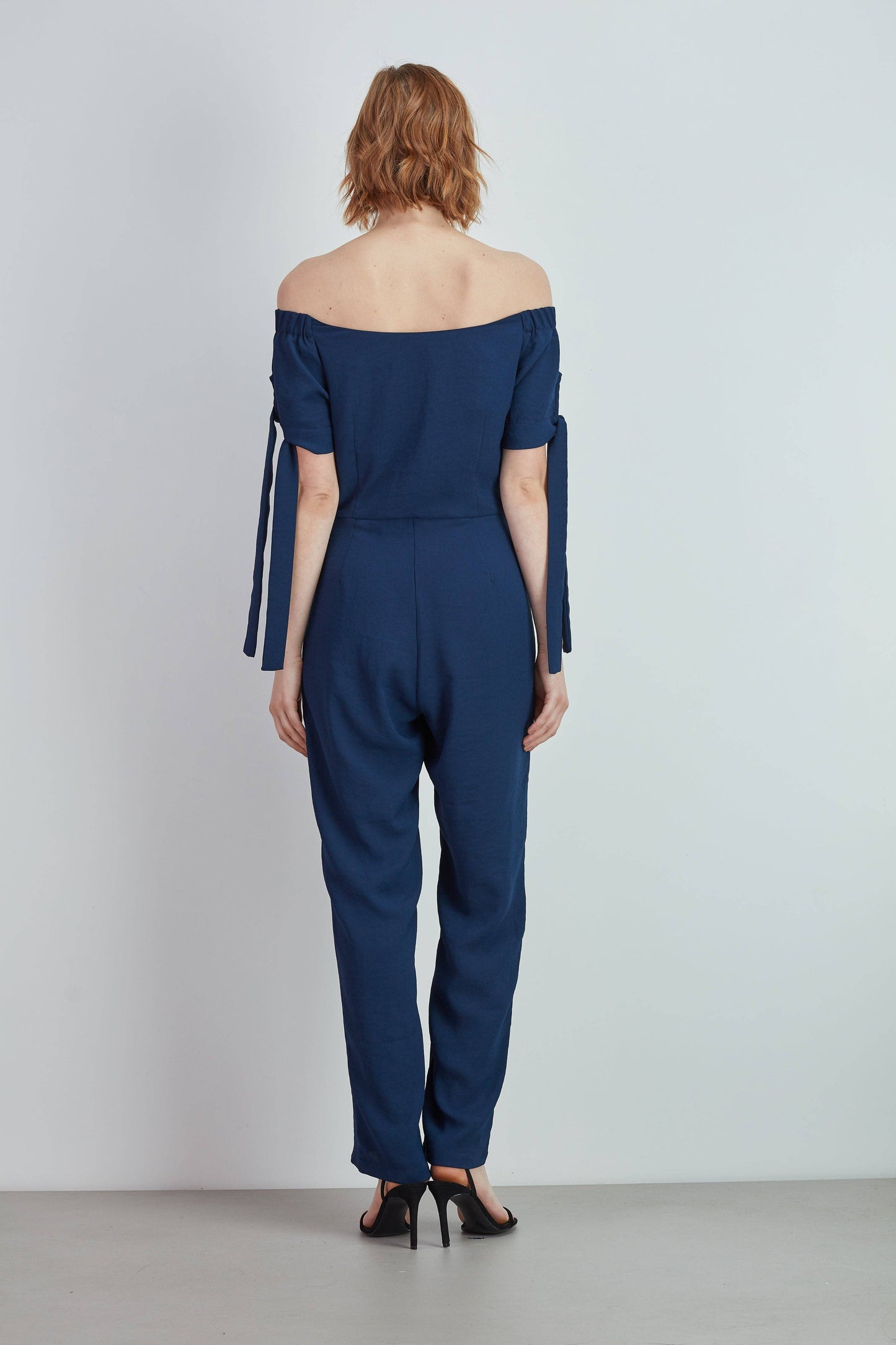 Tuta off-shoulder con bottoni dorati