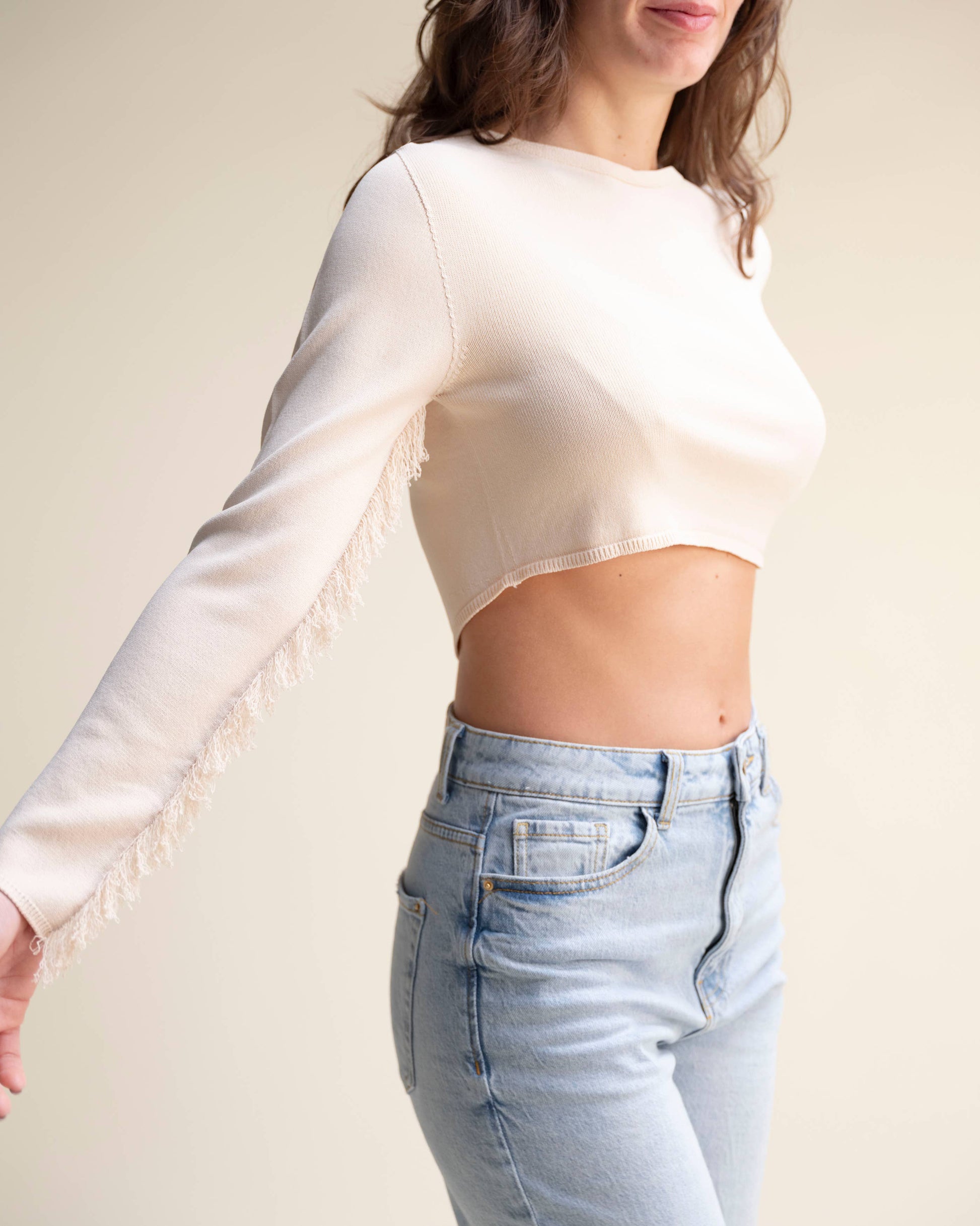 Top corto in maglia con frange sulle maniche