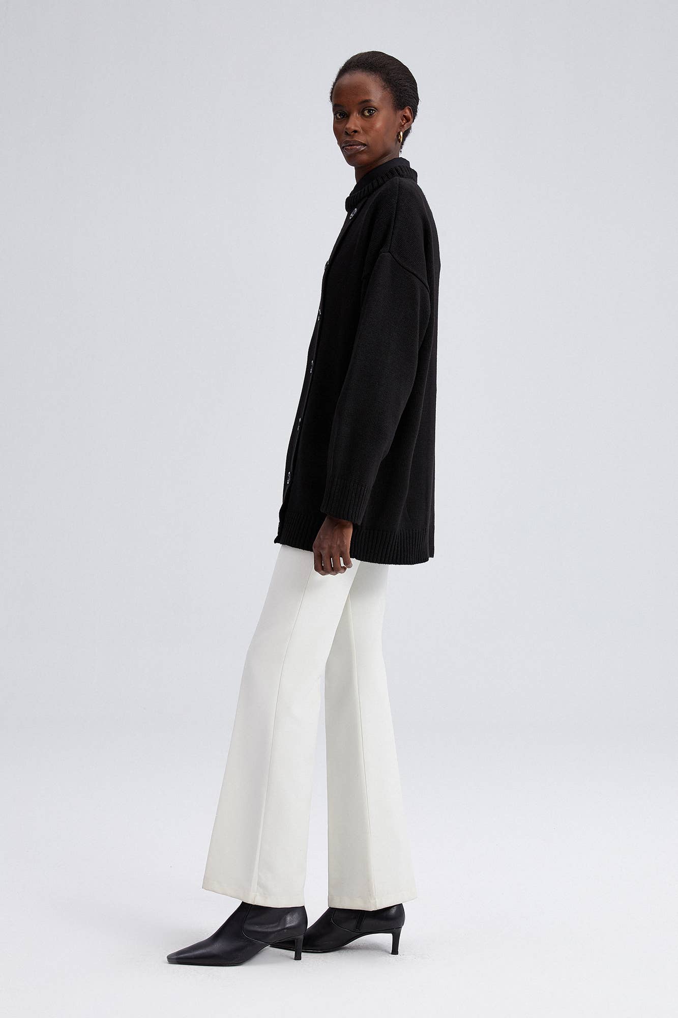 Maglione nero oversize con bottoni asimmetrici