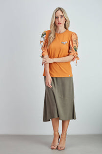 Top in cotone arancione con maniche a sbuffo floreali