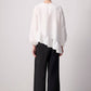 Blusa bianca con balza asimmetrica e maniche a palloncino