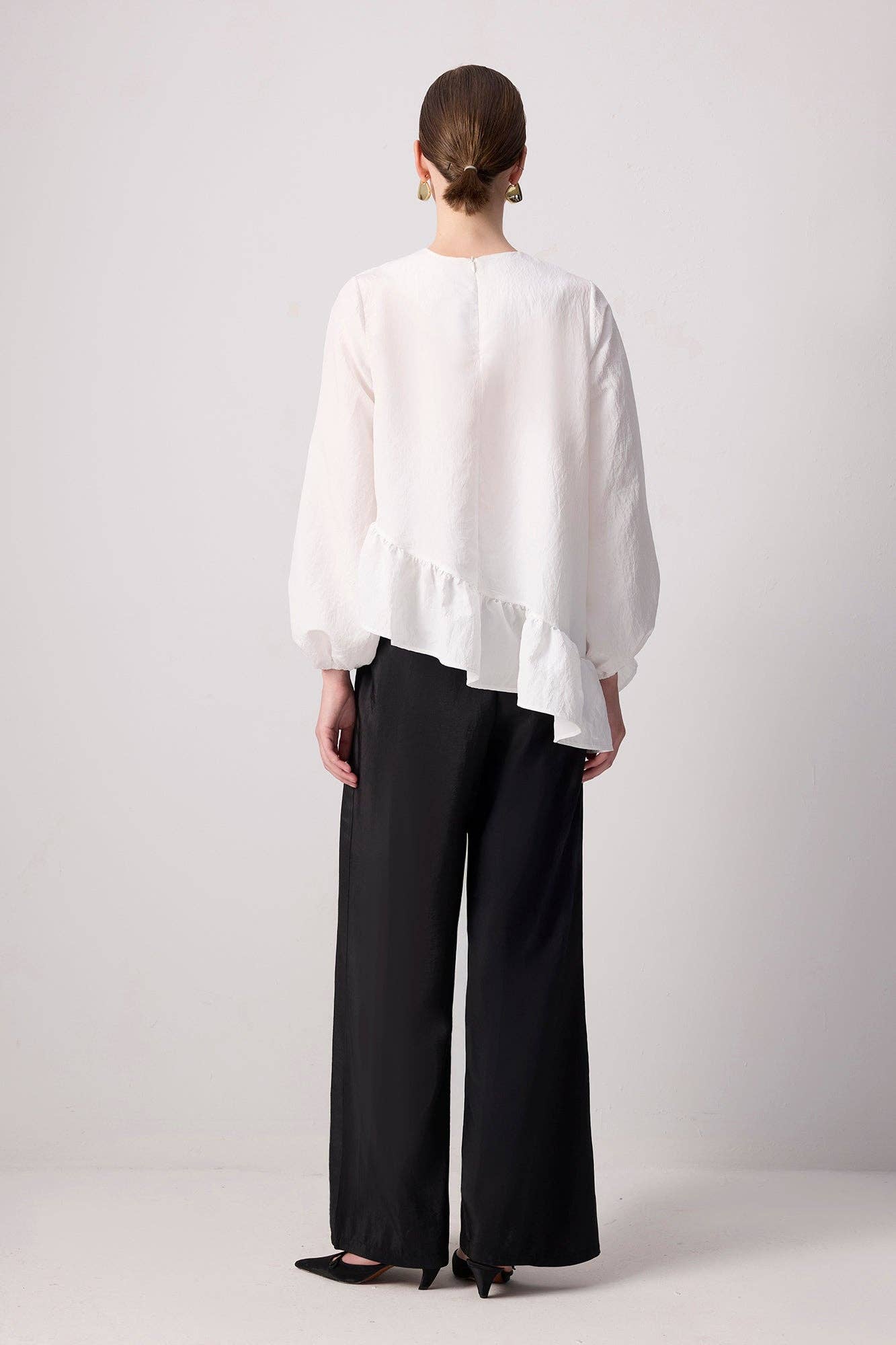 Blusa bianca con balza asimmetrica e maniche a palloncino