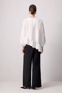 Blusa bianca con balza asimmetrica e maniche a palloncino