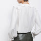 Blusa bianca con volant e laccio al collo