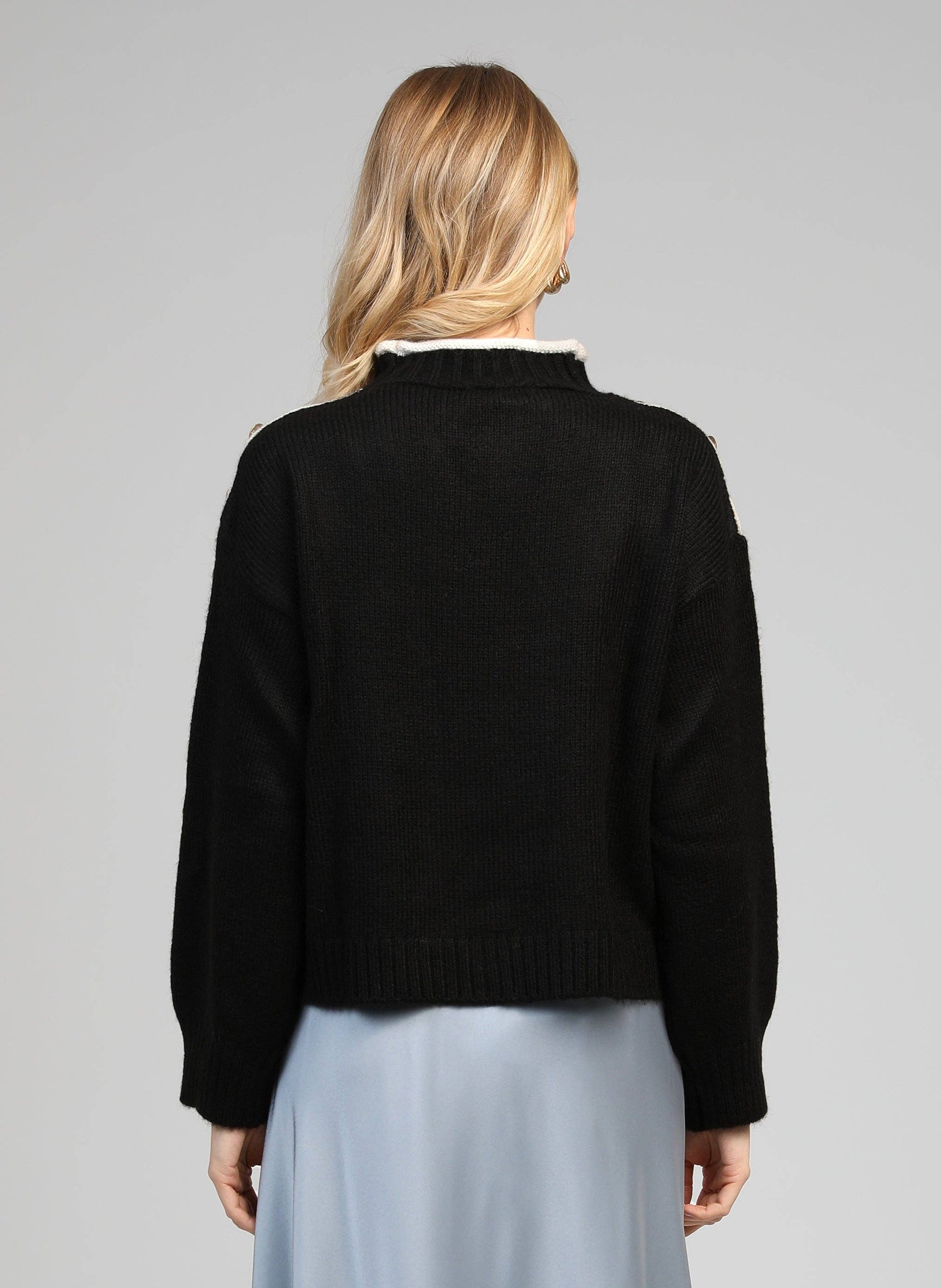 Maglione nero con collo alto e bottoni gioiello sulle spalle
