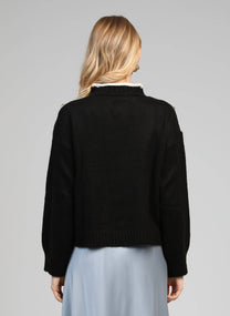 Maglione nero con collo alto e bottoni gioiello sulle spalle
