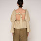 Blusa beige con volant e schiena aperta