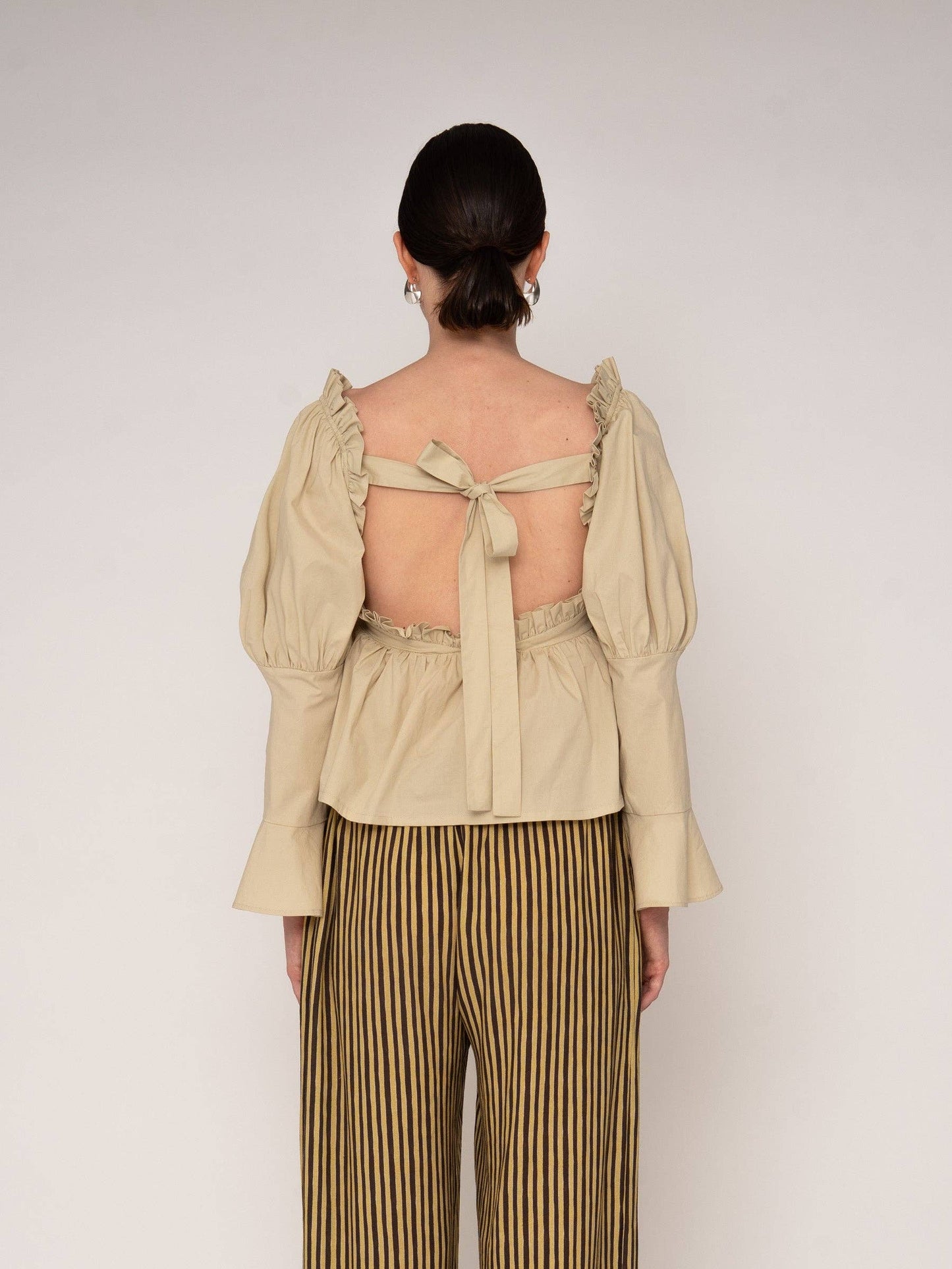 Blusa beige con volant e schiena aperta
