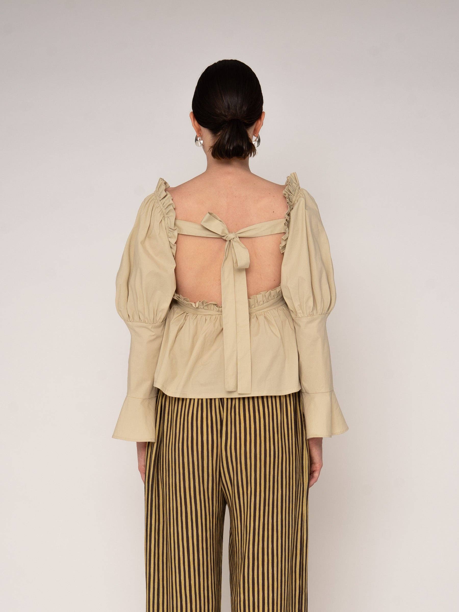 Blusa beige con volant e schiena aperta