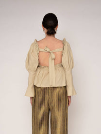 Blusa beige con volant e schiena aperta
