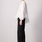 Blusa bianca con balza asimmetrica e maniche a palloncino