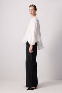 Blusa bianca con balza asimmetrica e maniche a palloncino