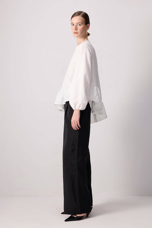 Blusa bianca con balza asimmetrica e maniche a palloncino