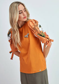 Top in cotone arancione con maniche a sbuffo floreali