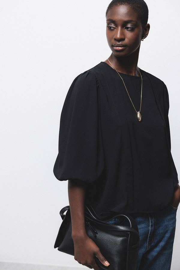 Blusa nera con pieghe e maniche a palloncino
