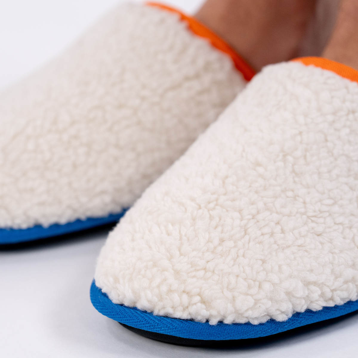 Pantofole in sherpa con dettagli arancioni e blu