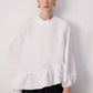 Blusa bianca con balza asimmetrica e maniche a palloncino