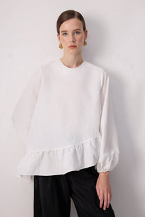 Blusa bianca con balza asimmetrica e maniche a palloncino