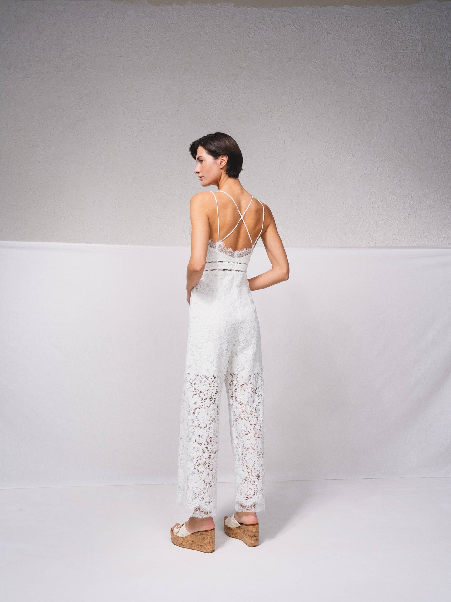 Tuta intera in pizzo con scollo a V e spalline incrociate
