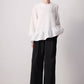 Blusa bianca con balza asimmetrica e maniche a palloncino