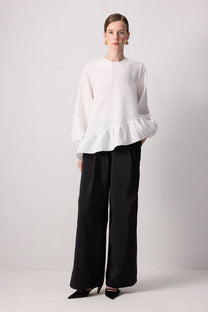 Blusa bianca con balza asimmetrica e maniche a palloncino