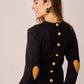 Maglione nero con toppe a cuore e bottoni sul retro