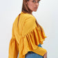 Blusa gialla con balze e pieghe sul petto