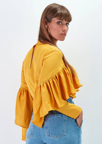 Blusa gialla con balze e pieghe sul petto
