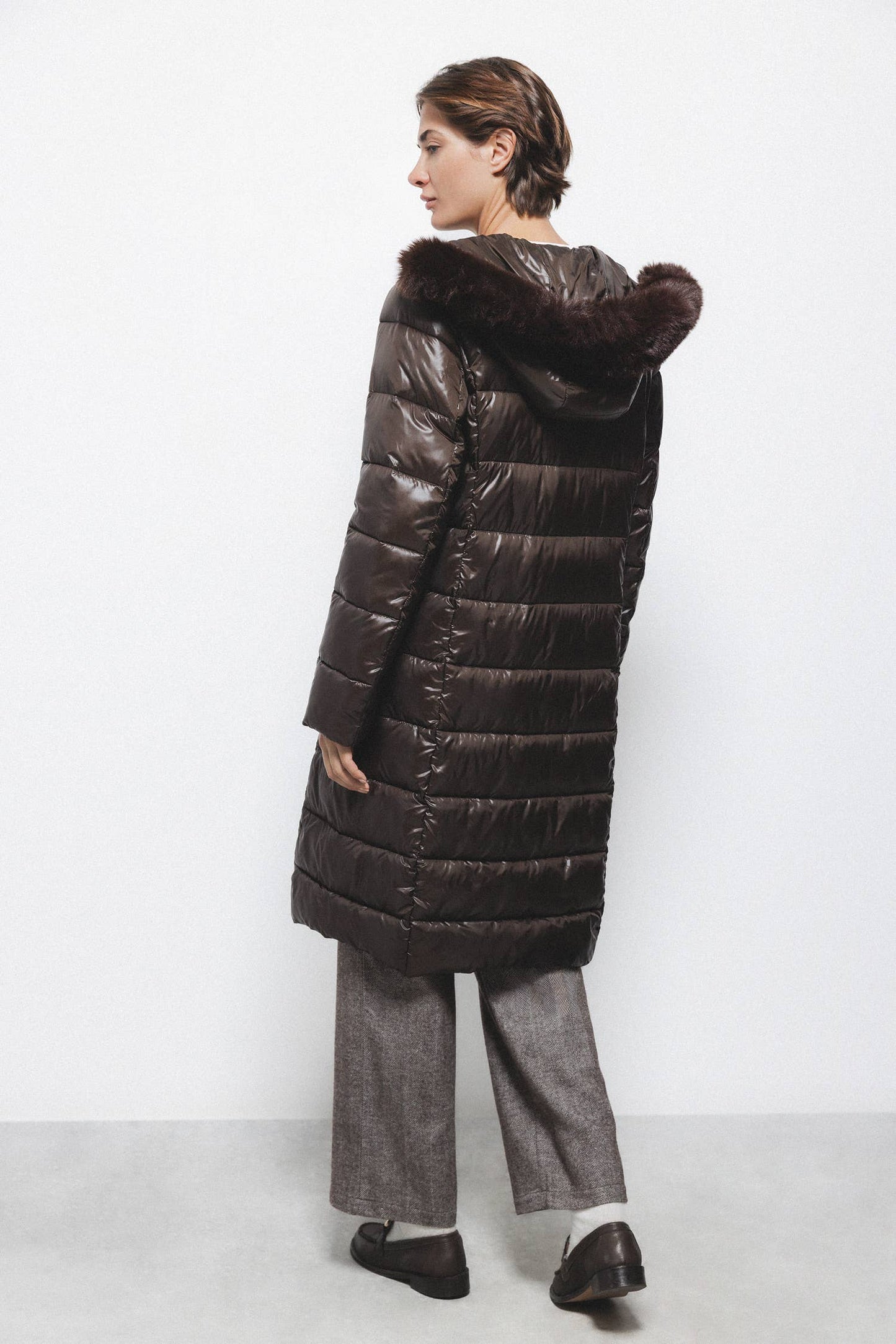 Cappotto lungo imbottito con cappuccio e bordatura in eco-pelliccia