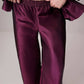 Completo in raso bordeaux con giacca asimmetrica e pantaloni a gamba larga