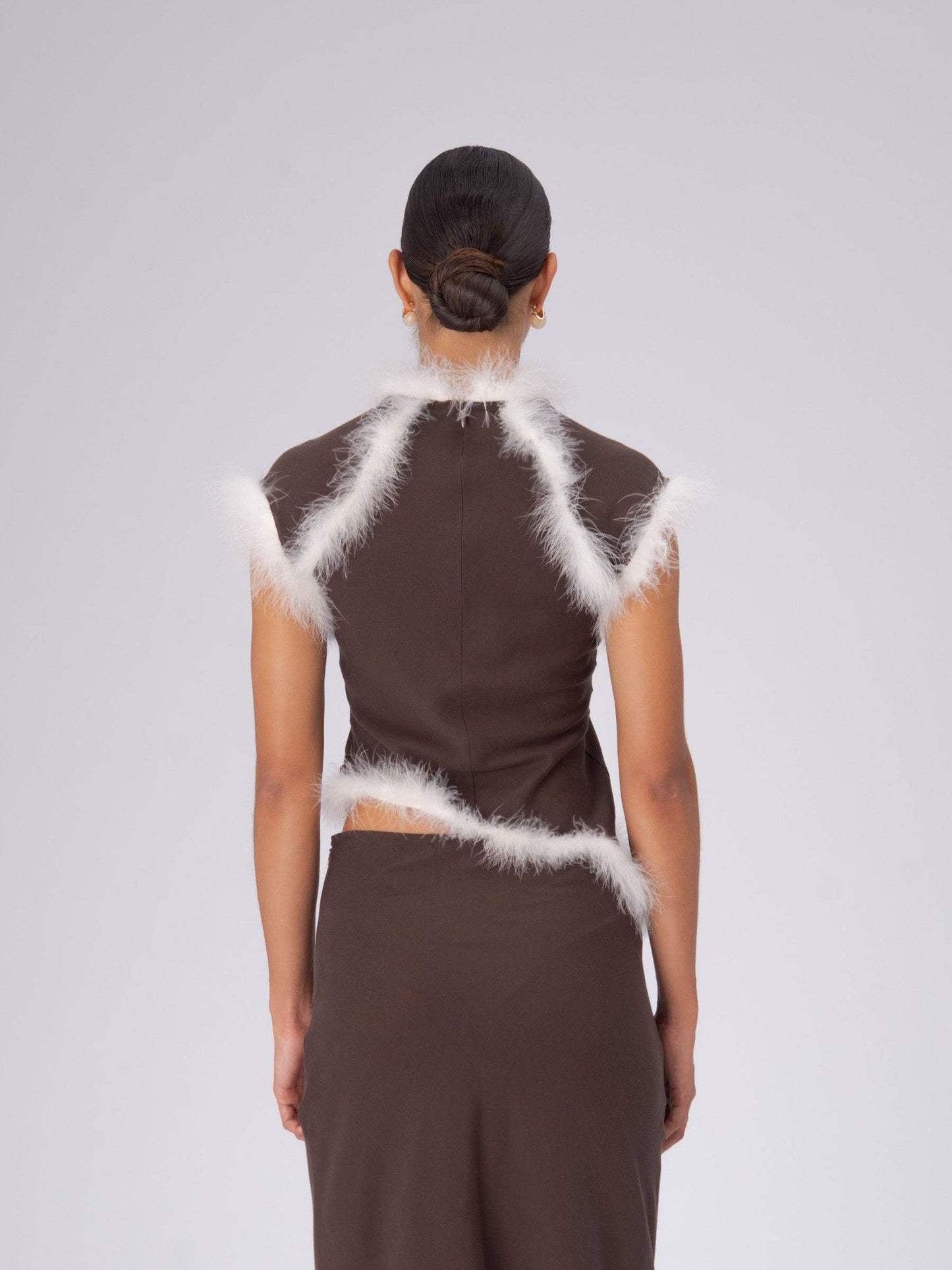 Top asimmetrico con piume marrone
