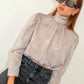 Blusa jacquard con collo alto e maniche a sbuffo