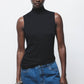 Top a collo alto con dettagli metallici