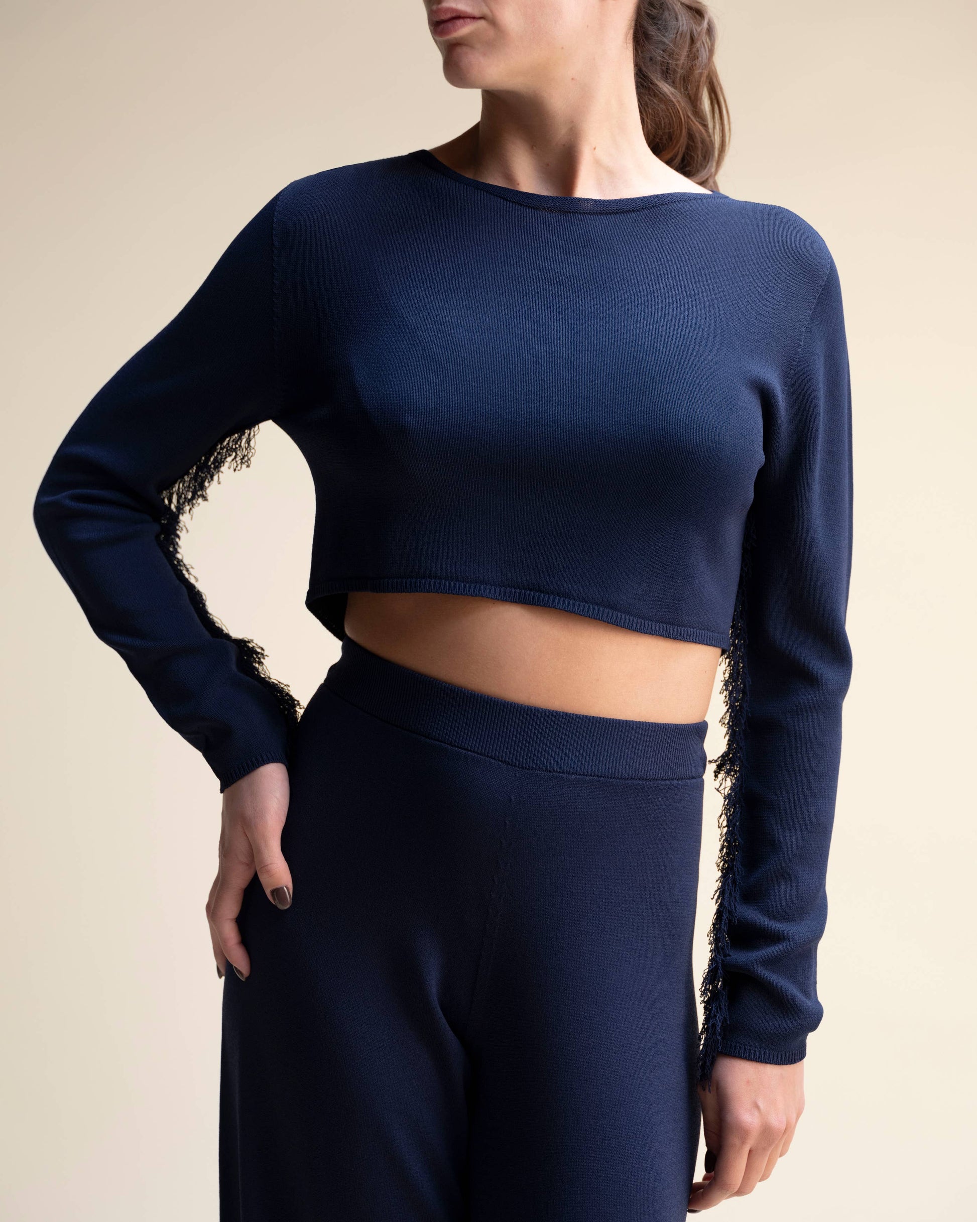 Top corto in maglia con frange sulle maniche