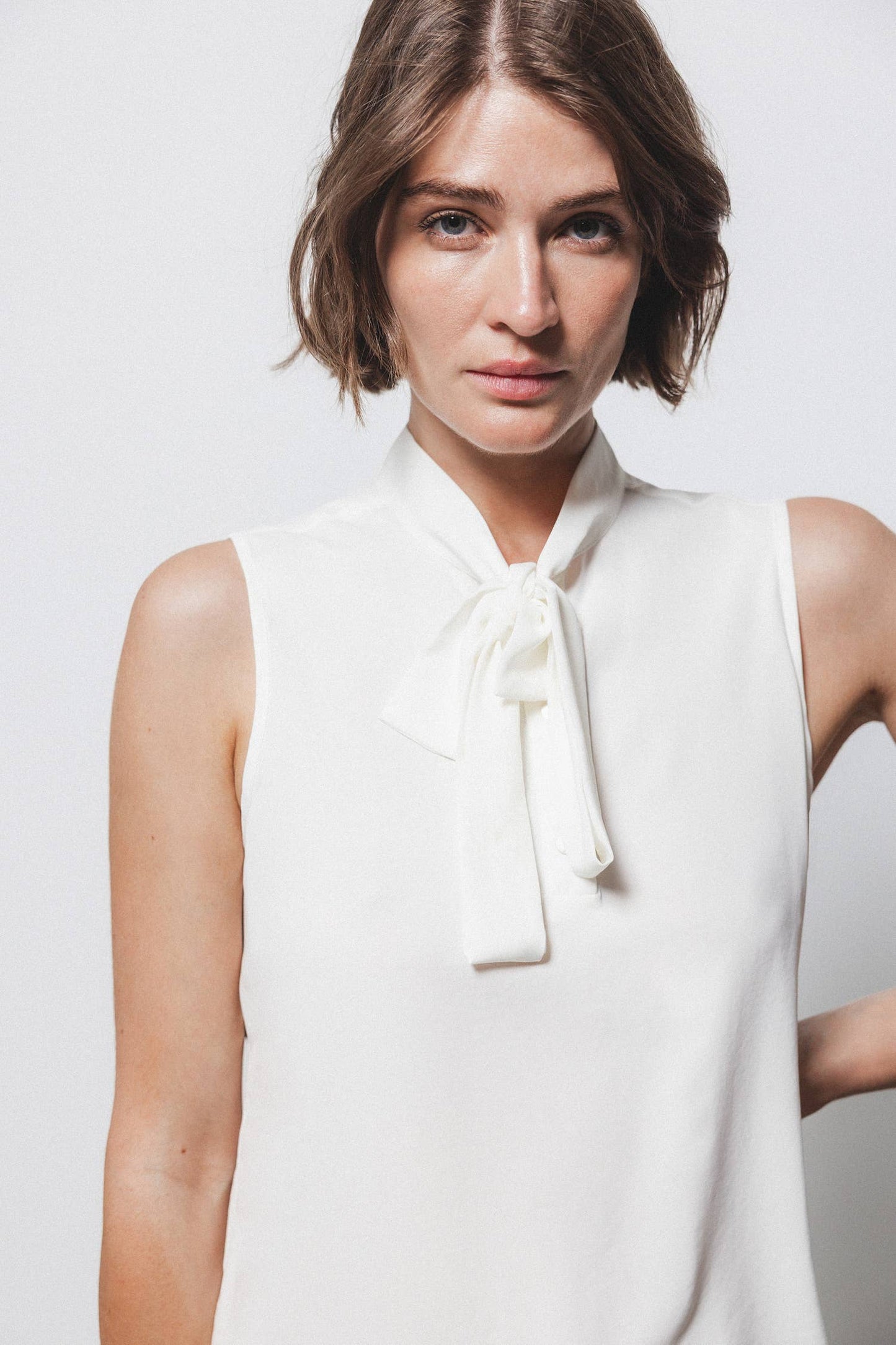 Top minimal con collo alto e fiocco
