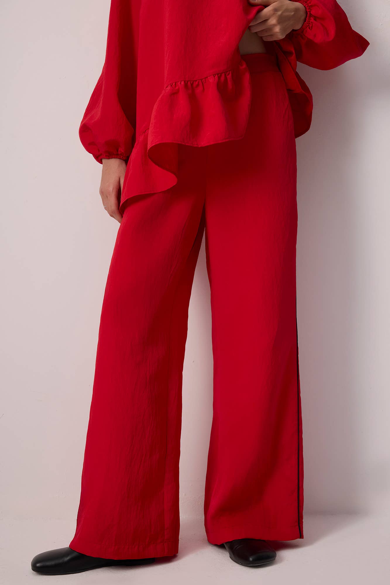 Pantaloni palazzo rossi effetto cupro con profili a contrasto