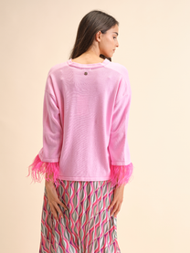Maglia rosa con polsini in piume
