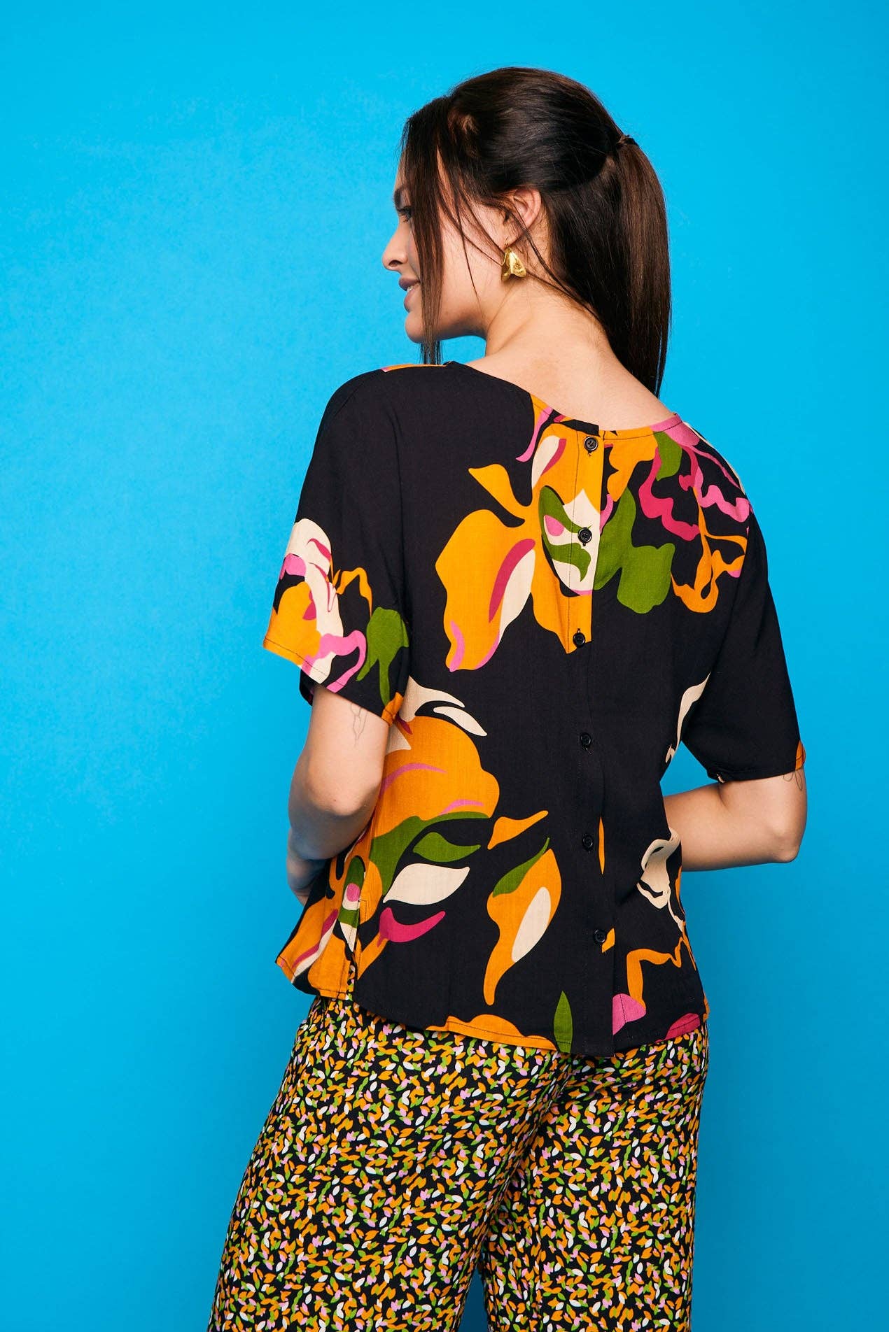 Camicia nera a maniche corte con stampa floreale e bottoni sul retro