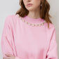 Maglione rosa con collo decorato in perle