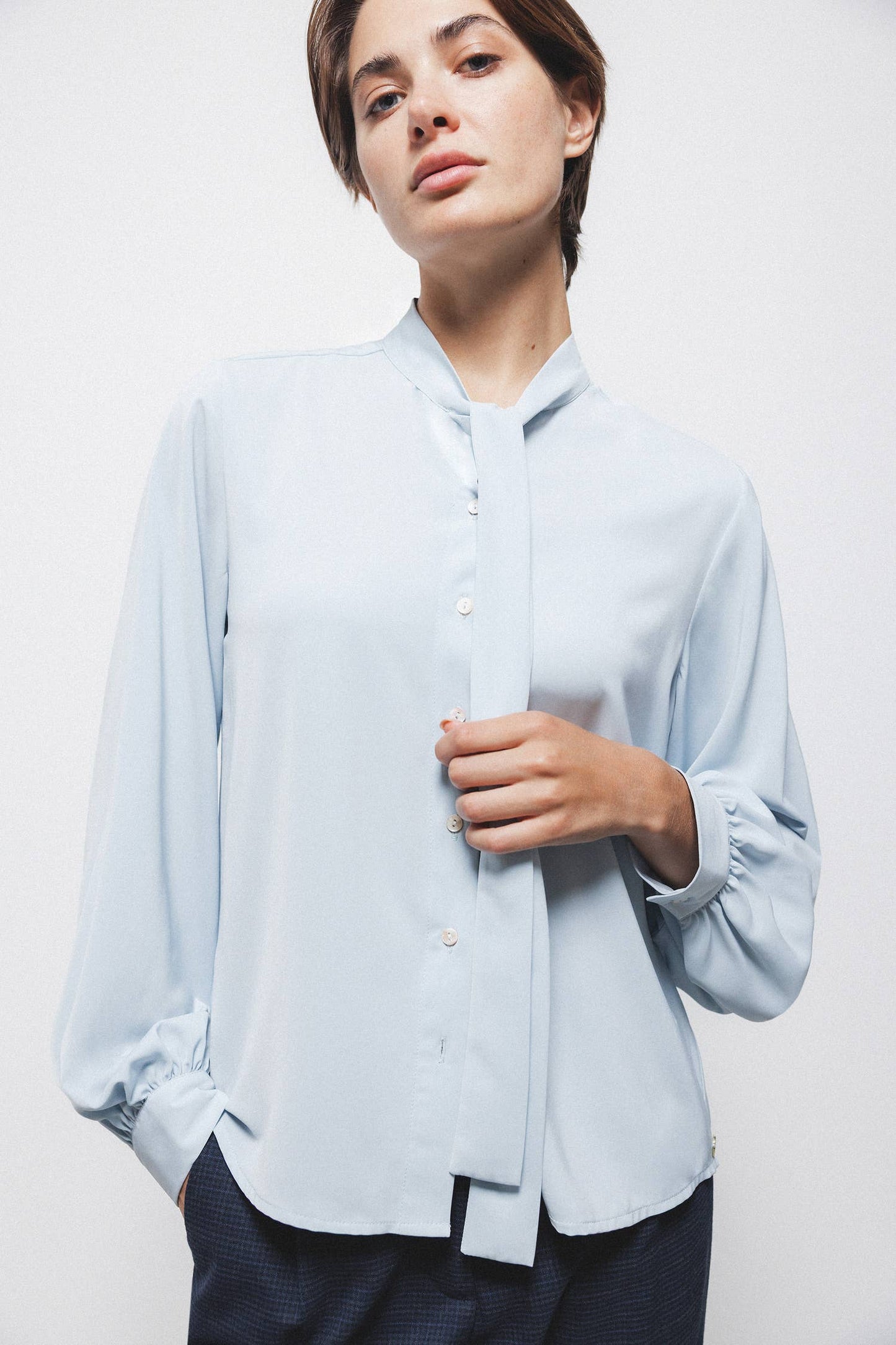 Blusa tinta unita con fiocco al collo