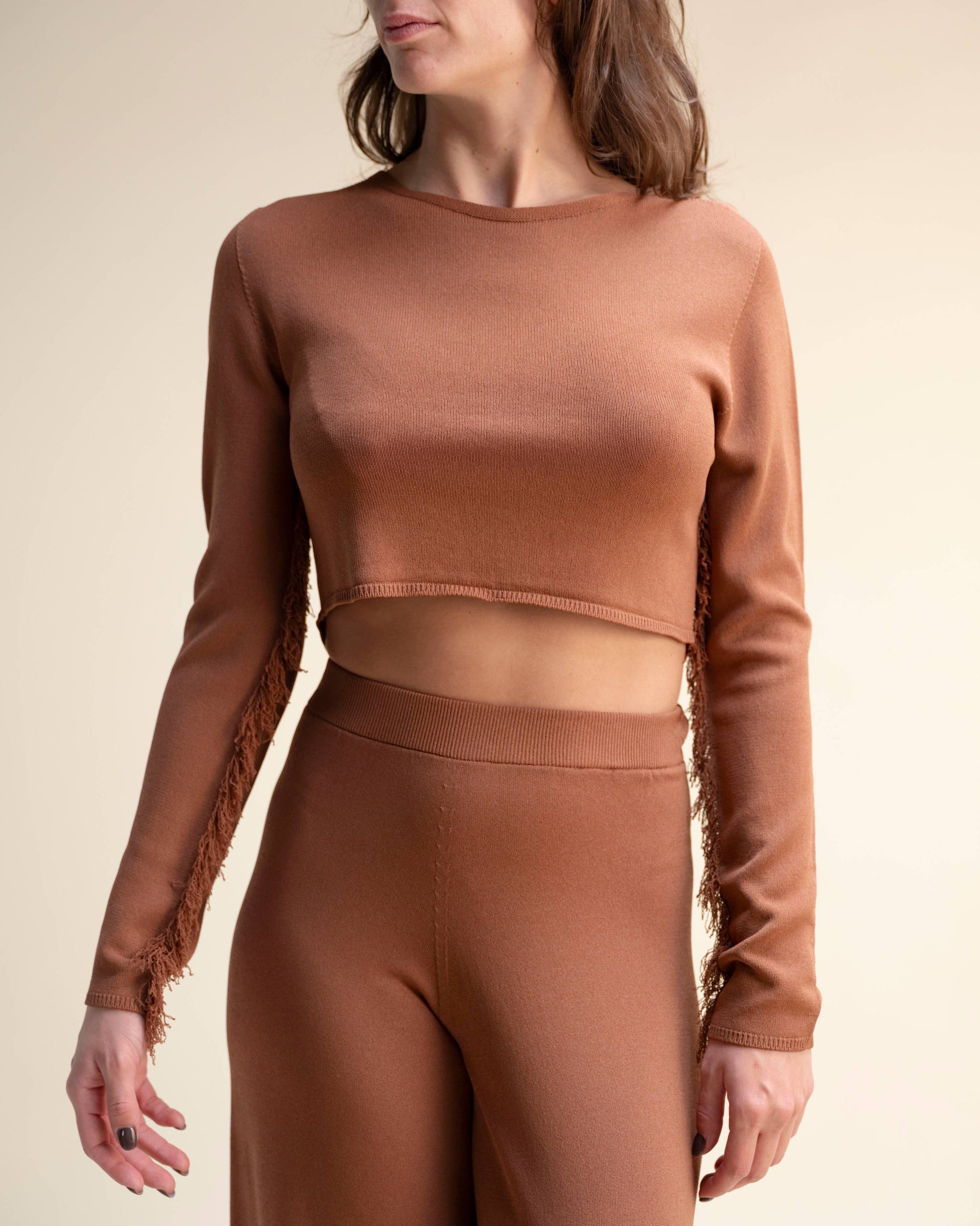 Top corto in maglia con frange sulle maniche