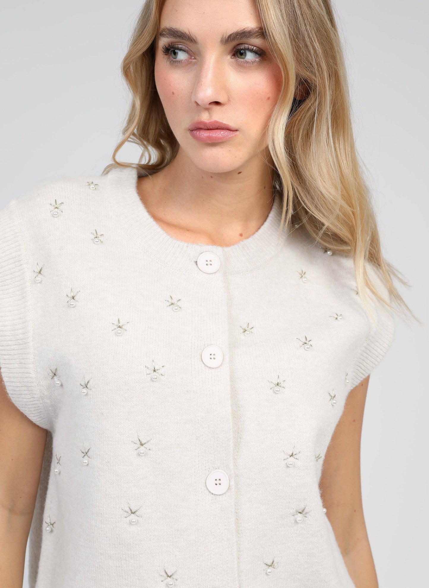 Cardigan smanicato in maglia écru con perle