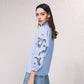 Blusa azzurra con maniche ricamate