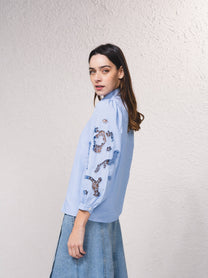 Blusa azzurra con maniche ricamate