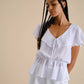 Blusa bianca con volant e scollo a V