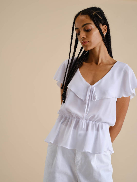 Blusa bianca con volant e scollo a V