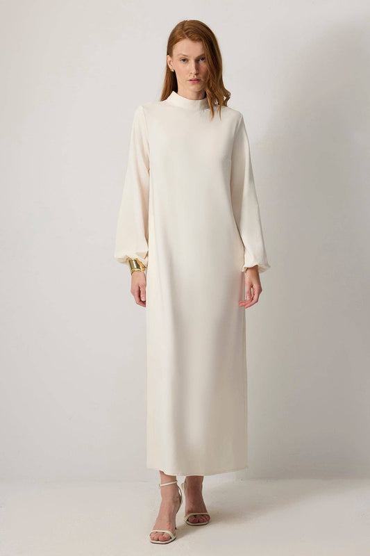 Abito lungo crema a collo alto con pannello laterale plissettato